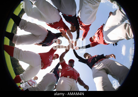 Una squadra di baseball con le loro mani impilati insieme in un huddle Foto Stock