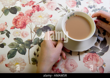 Una tazza di tè su una tovaglia floreale Foto Stock