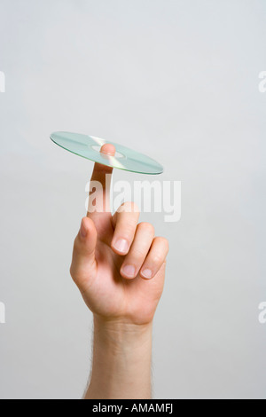 Dettaglio di un uomo con un CD sul suo dito Foto Stock