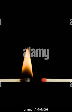 Un acceso matchstick accanto a un matchstick spento Foto Stock