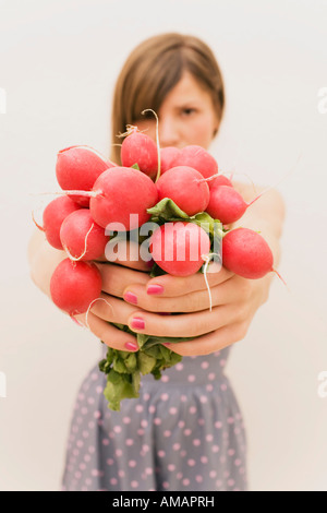 Donna che mantiene un mazzetto di ravanelli Foto Stock