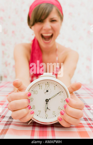 Una giovane donna in possesso di un orologio e urlando Foto Stock