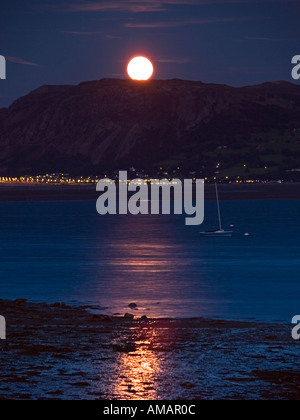 Luna si elevano al di sopra di MENAI stretto con la luna piena al di sopra di Tal y Fan Beaumaris Anglesey North Wales UK Foto Stock