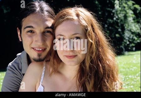 Giovane uomo abbracciando giovane donna, ritratto, close-up Foto Stock