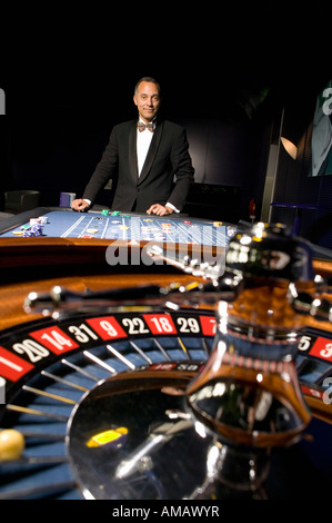 Ben vestito uomo giocare alla roulette in casino Foto Stock