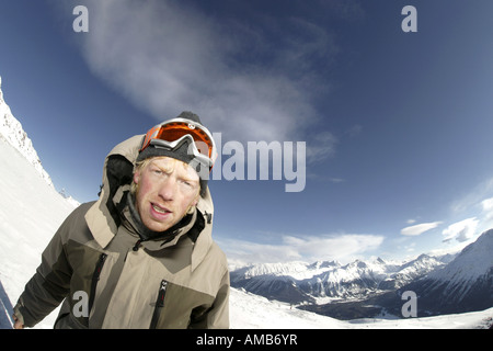 Giovani uomo biondo con gli occhiali di sky in montagna Foto Stock