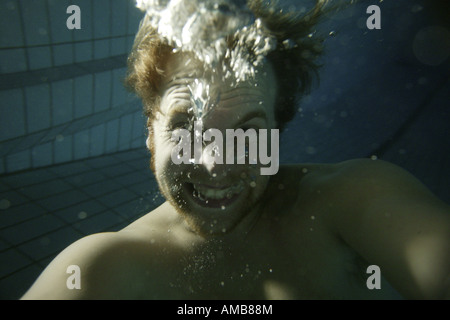 Crazy giovane uomo sotto l'acqua Foto Stock