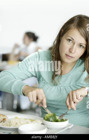 Giovane donna di mangiare nel refettorio di Ruhr-Universitaet Bochum, in Germania, in Renania settentrionale-Vestfalia, la zona della Ruhr, Bochum Foto Stock