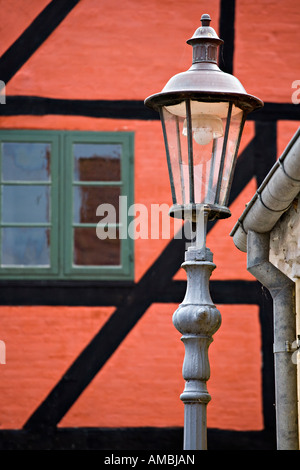 Lampione e metà Timbering un lampione con un tipico dipinto luminosamente in bianco e nero e rosso arancione graticcio dietro casa Foto Stock