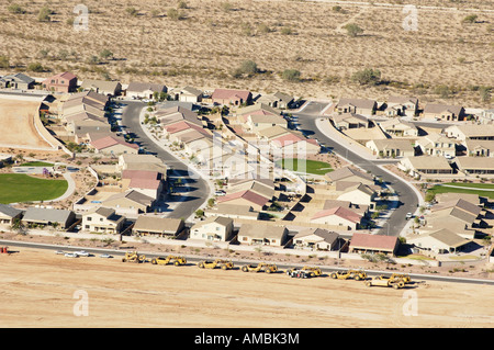 Attrezzature da costruzione schierate nei pressi di un alloggiamento dello sviluppo in Arizona la costruzione del bordo di un area residenziale Foto Stock