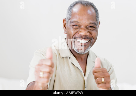 Ritratto di un uomo di mezza età rendendo un pollice in alto segno e sorridente Foto Stock