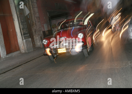 Cuba Havana notturni un classic car guida attraverso le strade di notte Foto Stock