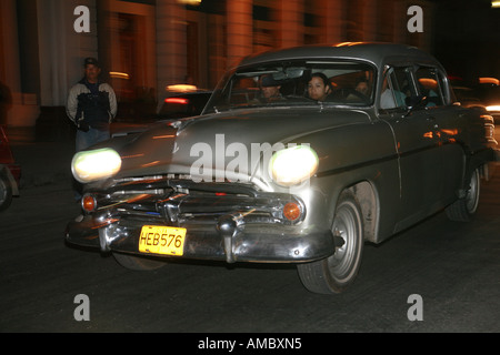 Cuba Havana notturni un classic car guida attraverso le strade di notte Foto Stock