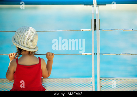 Ragazza cerca attraverso ringhiera Foto Stock