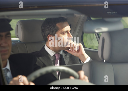 Imprenditore in auto con chauffeur Foto Stock