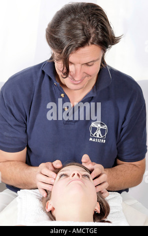 Giovane donna con astine massaggiato da uomo Foto Stock