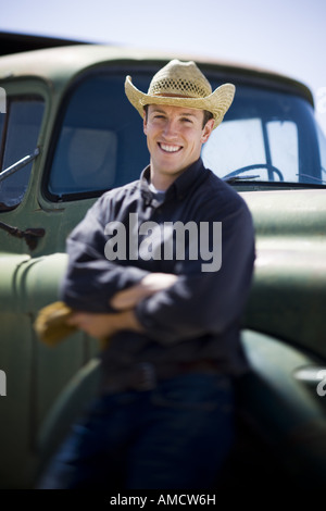 Uomo in il cappello da cowboy appoggiato sul carrello sorridente Foto Stock