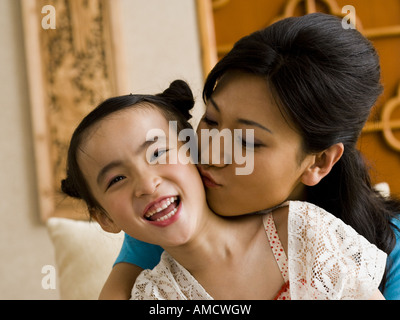 Madre figlia dando un bacio sulla guancia Foto Stock