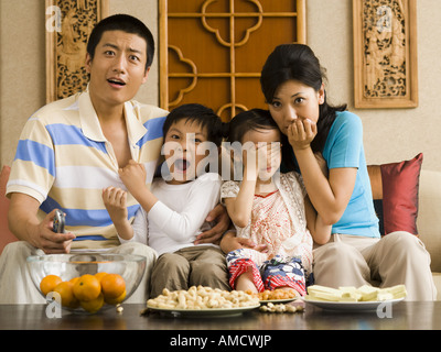 Scioccato la famiglia di guardare la televisione Foto Stock