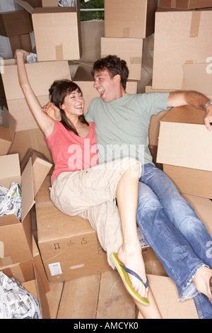 Giovane seduto tra i contenitori per il trasloco Foto Stock