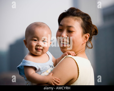 Donna che mantiene il bambino sorridente Foto Stock