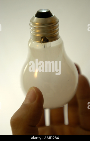 Mano che tiene la lampadina luce capovolta collo oro bianco verticale bkgrnd Foto Stock