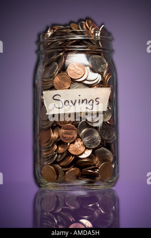 Vaso di vetro con etichetta del risparmio e delle monete metalliche in euro Foto Stock