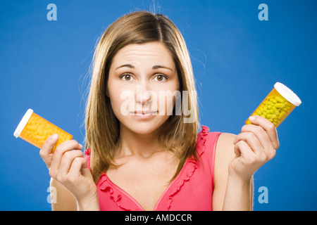 Donna che mantiene due bottiglie di capsule di prescrizione Foto Stock