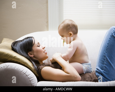 Donna sdraiata sul divano con il bambino Foto Stock
