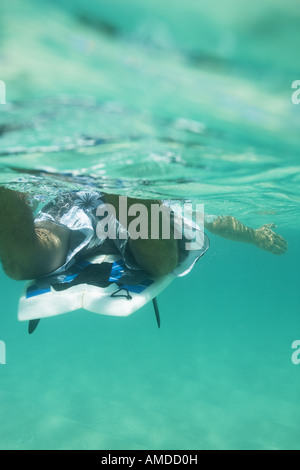 Uomo in acqua con la tavola da surf Foto Stock