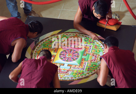 Quattro i monaci di lavoro su un quasi completato mandala Foto Stock