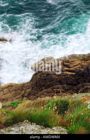 Guardando verso il basso di una scogliera sul mare tempestoso presso la costa rocciosa della Bretagna Francia Foto Stock