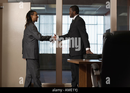 Vista di uomini d'affari stringono le mani in un ufficio. Foto Stock