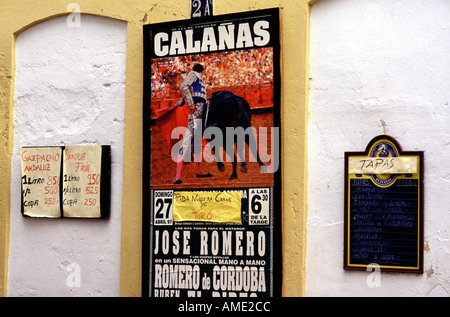 La corrida pubblicità e menu tapas impiccato nel muro esterno della Plaza de toros di Ronda una cima città nella provincia di Malaga in Andalusia Spagna Foto Stock