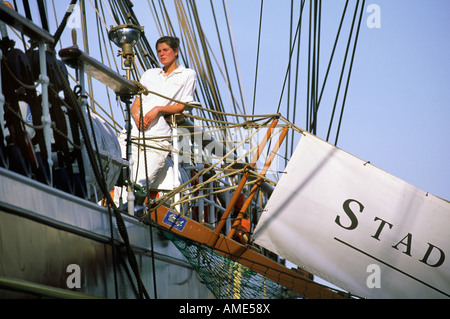 Una donna membro di equipaggio sorge nella parte superiore della passerella sul tallship Stad Amsterdam nel porto di Boston Foto Stock