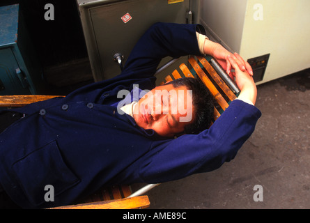 Lavoratore di Shanghai dormire dopo una lunga giornata di lavoro. L'economia cinese ha visto un ondata di lavoratori dalle campagne muoversi per la città per lavoro. Foto Stock