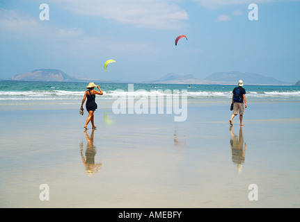 Coppia giovane camminando lungo la spiaggia di Famara. Lanzarote Island. Isole Canarie. Spagna. Foto Stock