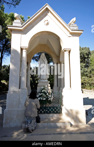 Donna prega prima della statua di Nostra Signora di Aljustrel, presso il punto in cui l'angelo apparve per la prima volta ai bambini di Fatima Foto Stock