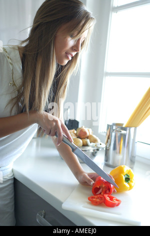 Donna di pepe di taglio in cucina Foto Stock