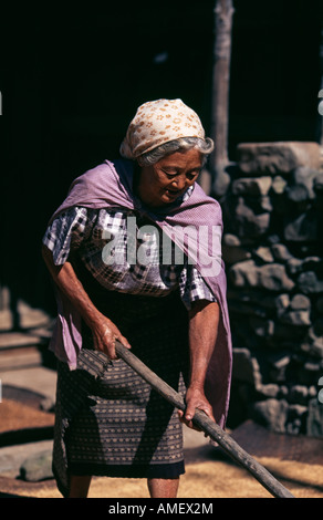 Agricoltore lavora al di fuori di una tradizionale casa tribali in Kigwema villaggio nei pressi di Kohima, Nagaland, India. Foto Stock