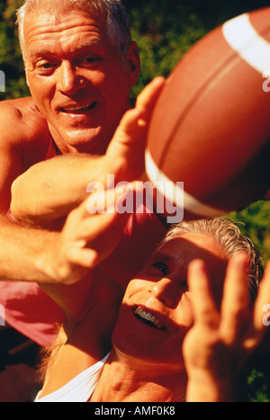 Gli uomini di età matura a giocare a calcio all'aperto Foto Stock