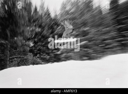 Snowboarder salti in aria Foto Stock