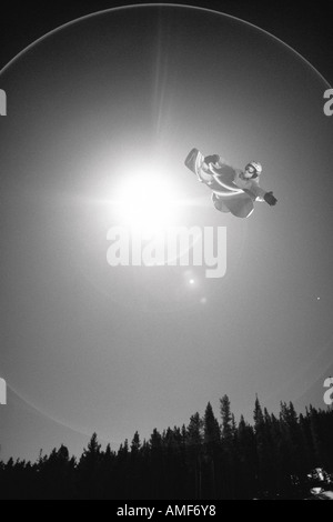 Snowboarder salti in aria Foto Stock