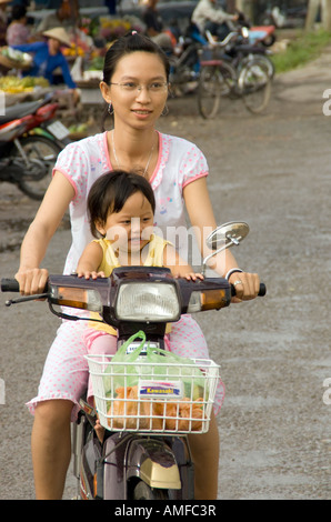 Madre con bambino sulla bici del motore nel fiume Mekong Delta Foto Stock