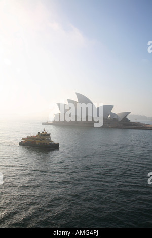 Mattinata nebbiosa come Sydney Harbour ferry passa la Opera House di Sydney Foto Stock