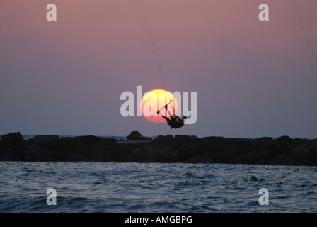 Il kite surf salto nel mare Mediterraneo Il surfer è il passaggio del sole al tramonto Foto Stock