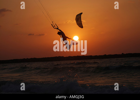 Il kite surf salto nel mare Mediterraneo Il surfer è il passaggio del sole al tramonto Foto Stock