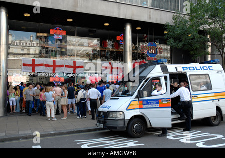 La polizia a guardare la gente a guardare una Coppa del Mondo 2006 partita di calcio al di fuori dello sport Café nell' Haymarket Londra Foto Stock