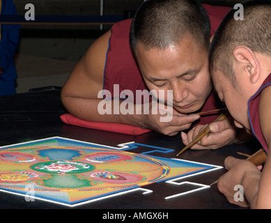 Monaci buddisti tibetani crea un mandala di sabbia (mandhala), una rappresentazione del cosmo, utilizzato nella purificazione dei diritti. Foto Stock