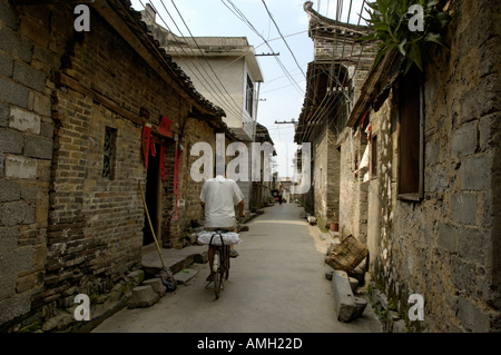 Cina Fuli Guangxi villaggio nei pressi di Yangshuo uomo in bicicletta nelle stradine della città Fuli Foto Stock